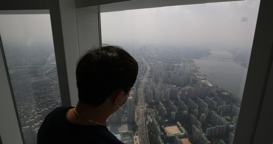 한 시민이 서울 송파구 한강변 아파트 단지를 바라보고 있다.<연합뉴스>